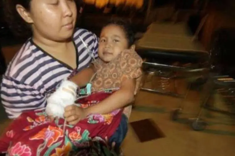 Criança ferida é levada para casa depois de receber atendimento médico na cidade de Medan (Sutanta Aditya/AFP)