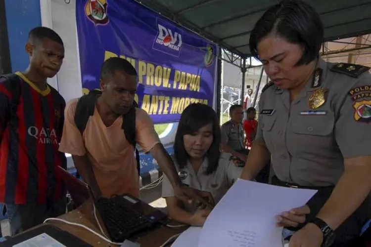 Policiais e familiares analisando lista de passageiros do voo da Trigana Air Service, na Indonésia
 (REUTERS/Lucky R/Antara Foto)