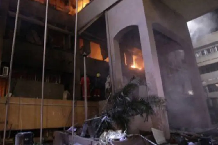 Bombeiros e equipes de resgate trabalham para apagar incêndio em prédio de Trípoli alvo de explosões (AFP)