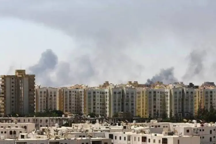 Focos de fumaça em estrada que leva ao aeroporto internacional de Tripoli, devido a combates entre milícias rivais (Mahmud Turkia/AFP)