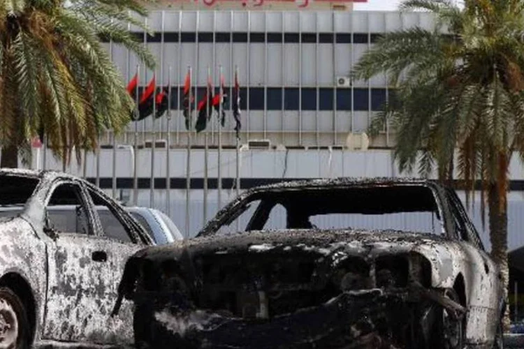 Carros queimados são vistos nos arredores do aeroporto internacional de Trípoli, Líbia: ONU anunciou a retirada de seus funcionários por motivos de segurança (Mahmud Turkia/AFP)