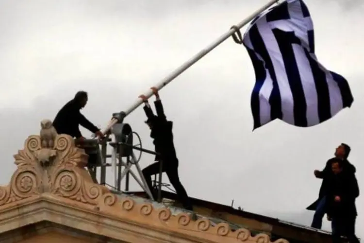 
	Pessoas trocam bandeira do Parlamento na Gr&eacute;cia: pesquisa tamb&eacute;m revelou que 52% dos gregos acreditam que a crise econ&ocirc;mica vai durar mais de 5 anos
 (Yannis Behrakis/Reuters)