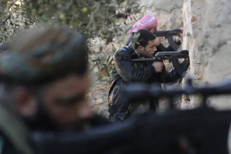 Soldados do Exército Livre da Síria durante uma troca de tiros com as forças leais ao presidente Bashar al-Assad (Muzaffar Salman/Reuters)