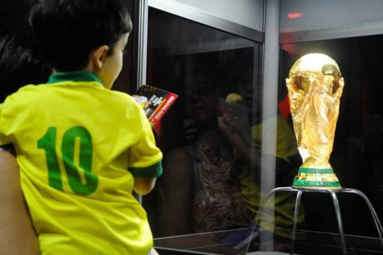 
	M&atilde;e e filho veem trof&eacute;u da Copa: previs&atilde;o do&nbsp;valor dos investimentos &eacute; de US$ 9 bilh&otilde;es
 (Tânia Rêgo/ABr)