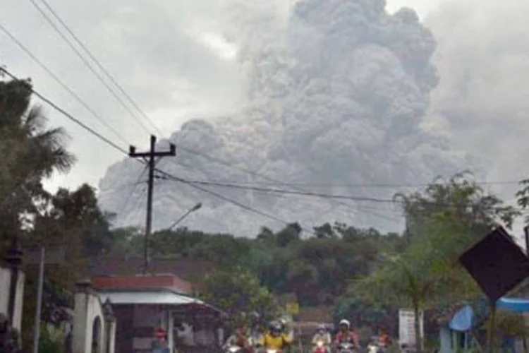Moradores fogem de moto do vilarejo de Jambu, próximo ao vulcão Monte Merapi. (Arya Bima/AFP)