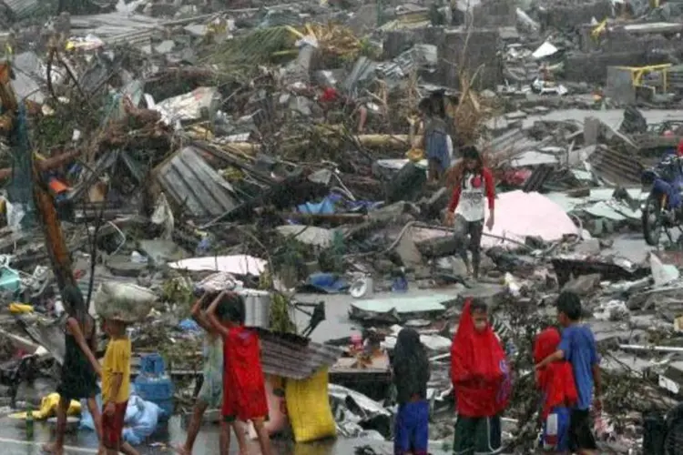 Pessoas carregam seus pertences após passagem do tufão nas Filipinas: autoridades confirmaram que seis pessoas permanecem desaparecidas (Getty Images)