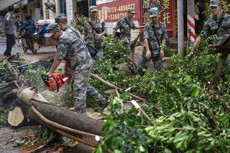 Soldados limpam a rua após passagem do tufão Rammasun na China (REUTERS/Stringer)