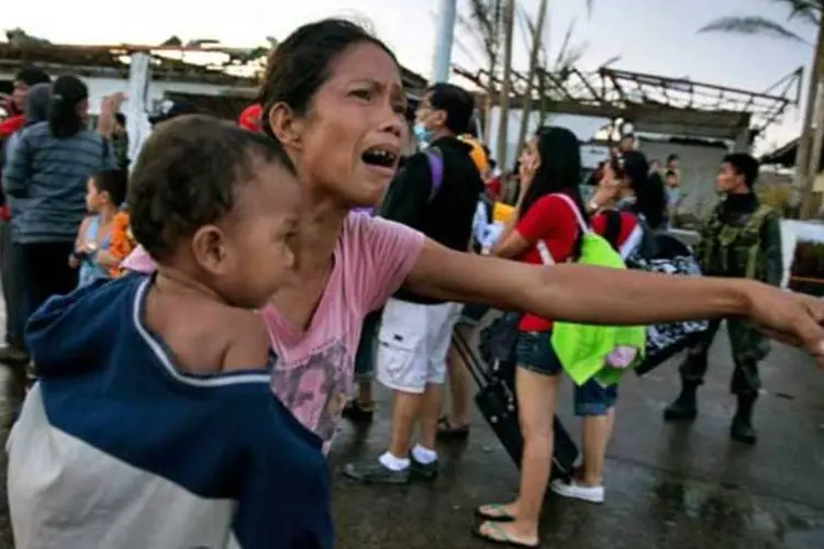 
	Mulher carregando uma crian&ccedil;a chora como outros sobreviventes do tuf&atilde;o Haiyan: n&uacute;mero de mortos confirmados pelo tuf&atilde;o supera j&aacute; os 1.700, segundo fontes oficiais
 (Getty Images)