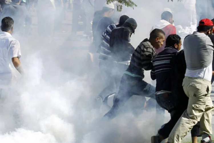 
	Tunisianos fogem de bombas de g&aacute;s: nos choques, as for&ccedil;as de seguran&ccedil;a usaram muni&ccedil;&atilde;o real e g&aacute;s lacrimog&ecirc;neo contra os manifestantes
 (REUTERS)