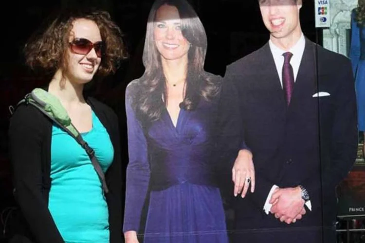 Turista posa ao lado das fotos de William e Kate Middleton: instituto de pesquisa estima que a cerimônia vai atrair 360 mil visitantes (Getty Images)