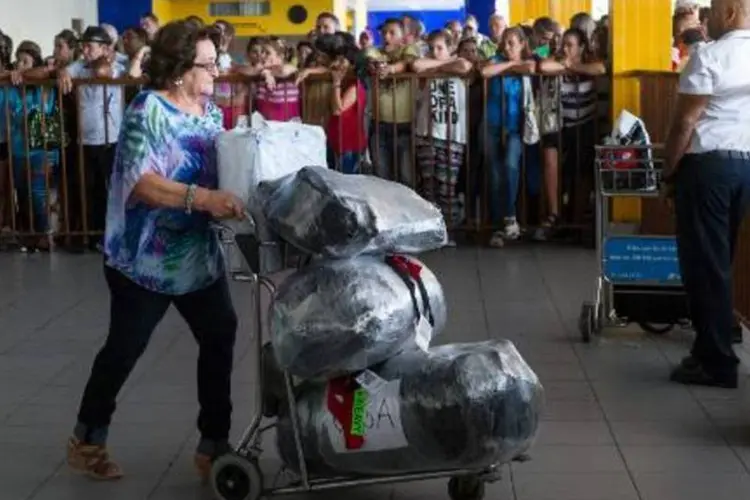 Uma mulher chega com suas bagagens ao Aeroporto Internacional José Martí, a 14,5 km do centro de Havana (Yamil Lage/AFP)