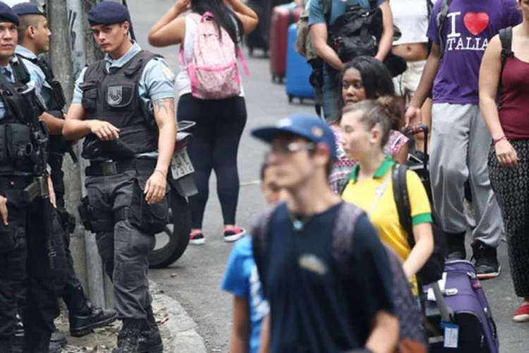 
	Policiais observam turistas carregando bagagens no Rio: Jap&atilde;o alertou seus turistas a guardarem c&acirc;meras e smartphones
 (Mario Tama/Getty Images)