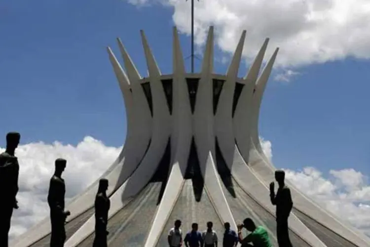 
	Turistas tiram fotos em frente &agrave; Catedral Metropolitana de Bras&iacute;lia, projetada por Oscar Niemeyer
 (REUTERS/Jamil Bittar/Arquivo)