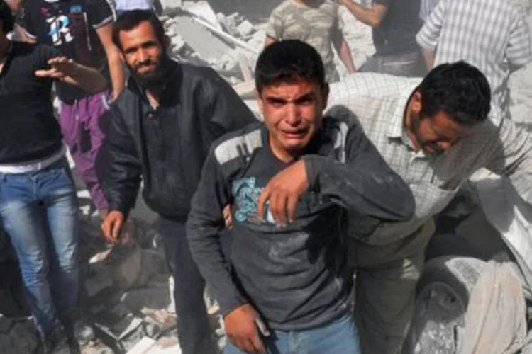 
	Homens reagem a ataque a&eacute;reo realizado pelas for&ccedil;as do regime s&iacute;rio em Maaret al-Numan: a crise s&iacute;ria j&aacute; dura 20 meses
 (Bulent Kilic/AFP)