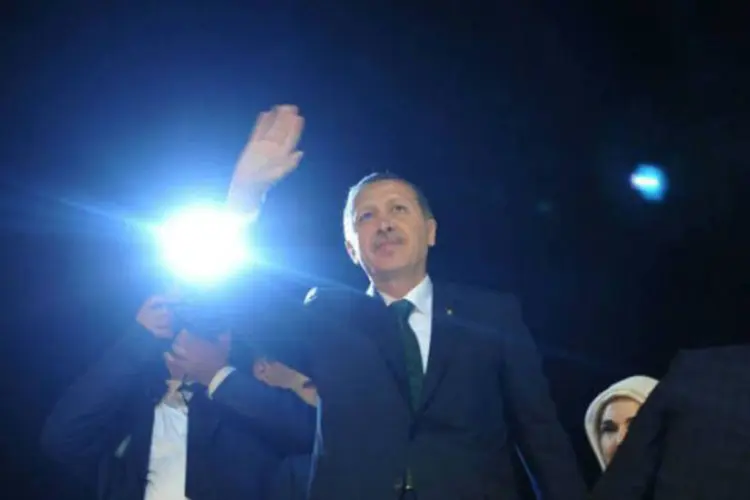 O primeiro-ministro da Turquia Recep Tayyip Erdogan acena para simpatizantes no aeroporto internacional de Istambul (AFP/ Ozan Kose)