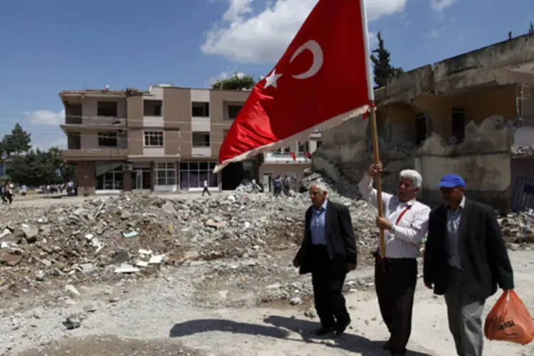 Homem caminha pelos prédios danificados na cidade de Reyhanli, perto da fronteira turca com a Síria (Umit Bektas/Reuters)