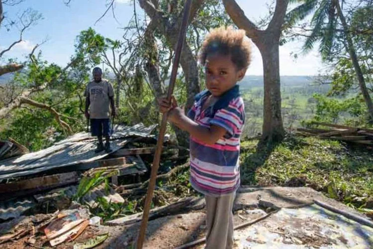 Ruínas: criança e pai vasculham destroços de casa atingida pelo ciclone Pam, em Tuvalu, em 2015. (UNICEF/Getty Images)