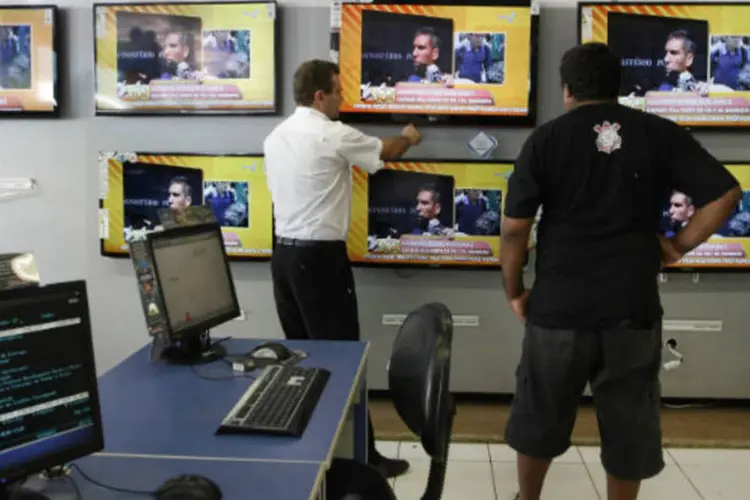 Varejo: atendente de vendas mostra televisores para cliente em loja das Casas Bahia (REUTERS/ Nacho Doce)