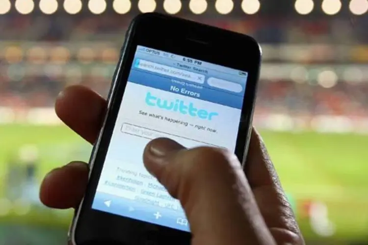 Torcedor acessa o Twitter através da internet móvel de seu iPhone (Cameron Spencer/Getty Images)