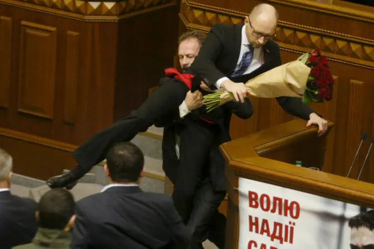 
	O primeiro-ministro Arseniy Yatsenyuk &eacute; arrastado pelo deputado Oleh Barna no Parlamento
 (Valentyn/Reuters)