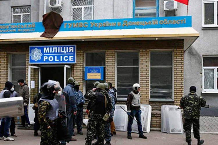 
	Homens armados em frente a escrit&oacute;rio da pol&iacute;cia em Slaviansk: a cidade ainda n&atilde;o fora alvo de protestos pr&oacute;-Moscou
 (REUTERS/Gleb Garanich)