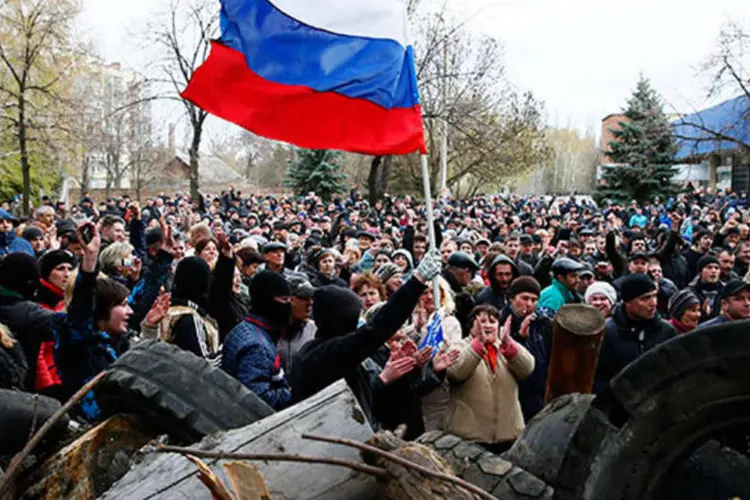 
	Pr&oacute;-russos balan&ccedil;am bandeira da R&uacute;ssia em Slaviansk:&nbsp;carros blindados avan&ccedil;aram da cidade de Kramatorsk, a cerca de 15 km ao sul de Slaviansk
 (REUTERS/Gleb Garanich)