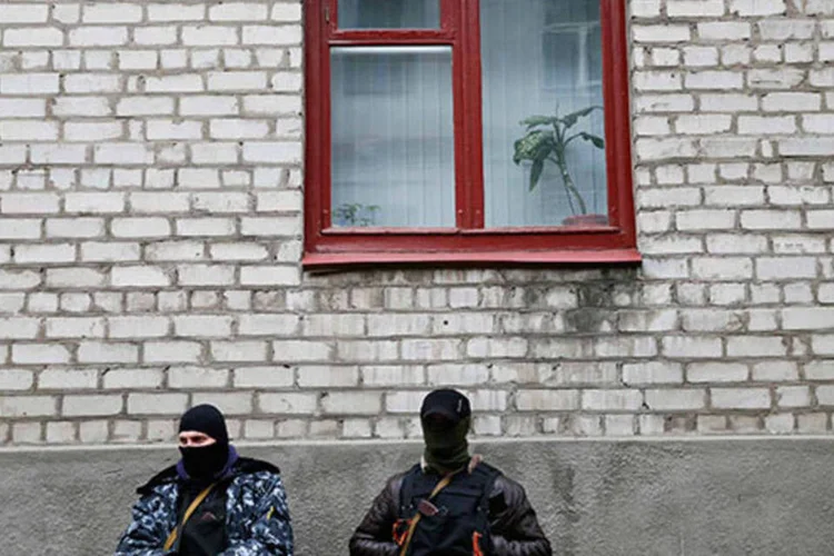 
	Homens armados ficam em frente ao escrit&oacute;rio da pol&iacute;cia em Slaviansk, na Ucr&acirc;nia: a bandeira ucraniana foi retirada dos pr&eacute;dios da pol&iacute;cia
 (REUTERS/Gleb Garanich)