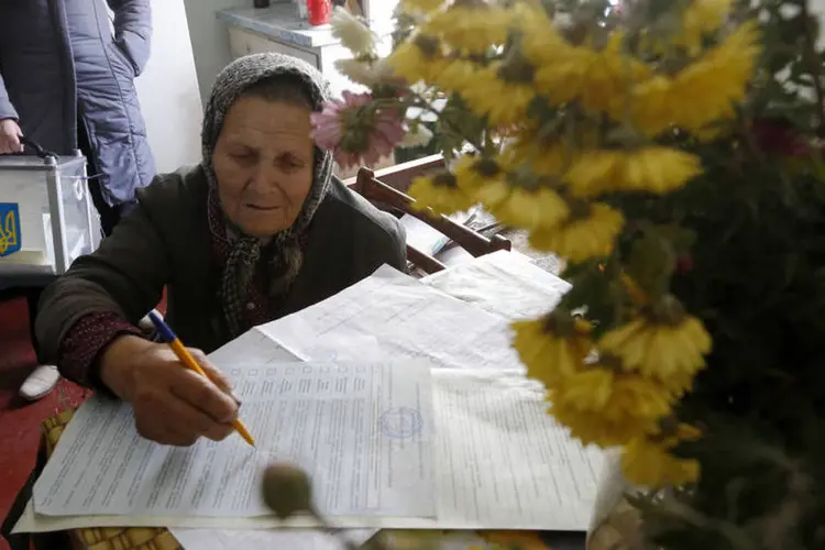 Ucraniana preenche uma cédula de votação durante as eleições parlamentares, na vila de  Horodyshche, próximo de Chernihiv (Reuters)