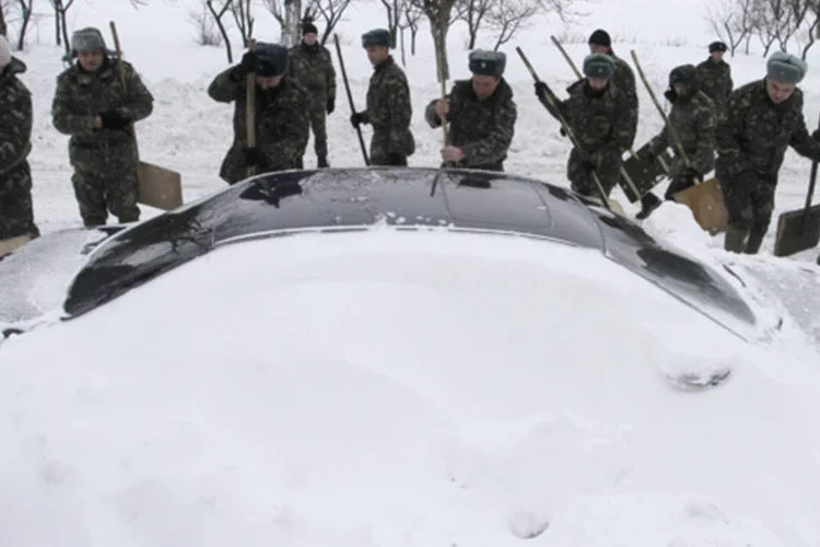 
	Equipes de emerg&ecirc;ncia removem a neve de um carro preso ap&oacute;s nevascas em Brody: autoridades desaconselham os motoristas a sair de carro
 (Marian Striltsiv/Reuters)