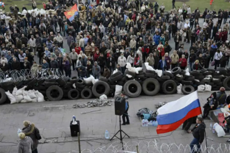 
	Manifestantes pr&oacute;-Russia do lado de fora de pr&eacute;dio do governo em Donetsk: primeiro-ministro russo, Dmitry Medvedev, fez uma avalia&ccedil;&atilde;o sombria depois que ao menos duas pessoas morreram no domingo
 (Maks Levin/Reuters)