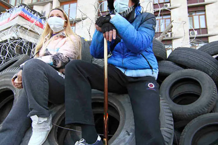Manifestantes pró-Rússia sentam em pneus do lado de fora do prédio do governo regional em Donetsk, na Ucrânia  (REUTERS/Stringer)