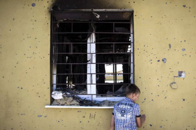 
	Na fronteira entre Ucr&acirc;nia e R&uacute;ssia, um menino recolhe c&aacute;psulas de balas disparadas ap&oacute;s confronto
 (REUTERS/Shamil Zhumatov)