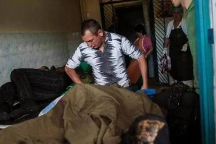 Homem carrega corpo de soldado morto por separatistas ucranianos, em 22 de maio de 2014, em Volnovakha	 (AFP)