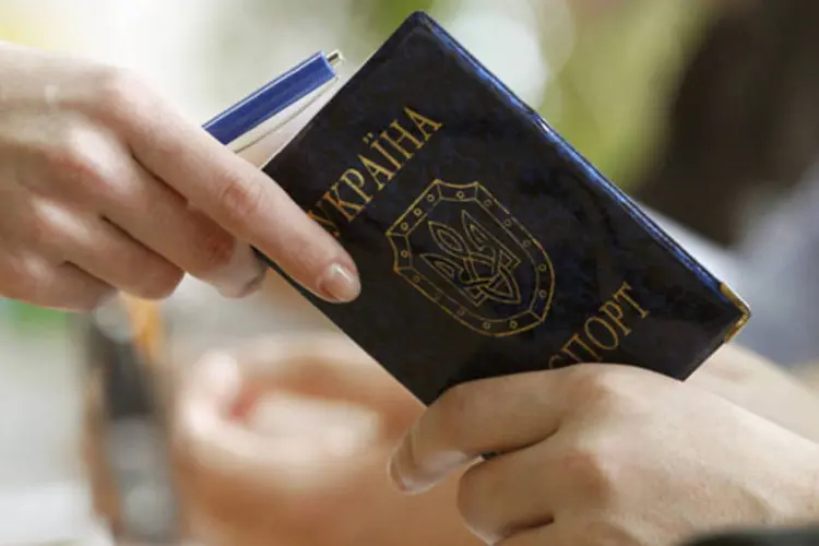 
	Oficial observa passaporte de cidad&atilde;o ucraniano: &quot;A R&uacute;ssia insiste no t&eacute;rmino incondicional dessas pr&aacute;ticas irrespons&aacute;veis da Ucr&acirc;nia, que amea&ccedil;am a seguran&ccedil;a de voos da avia&ccedil;&atilde;o civil&quot;, declarou minist&eacute;rio
 (REUTERS/Vasily Fedosenko)