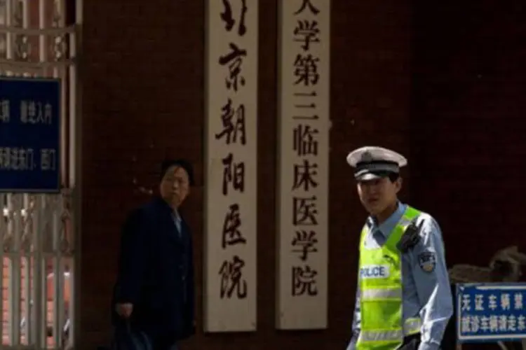 Um policial patrulha a entrada do hospital onde Chen Guangcheng está internado, em Pequim: a China aceitou conceder "o mais rápido possível" os passaportes (Ed Jones/AFP)