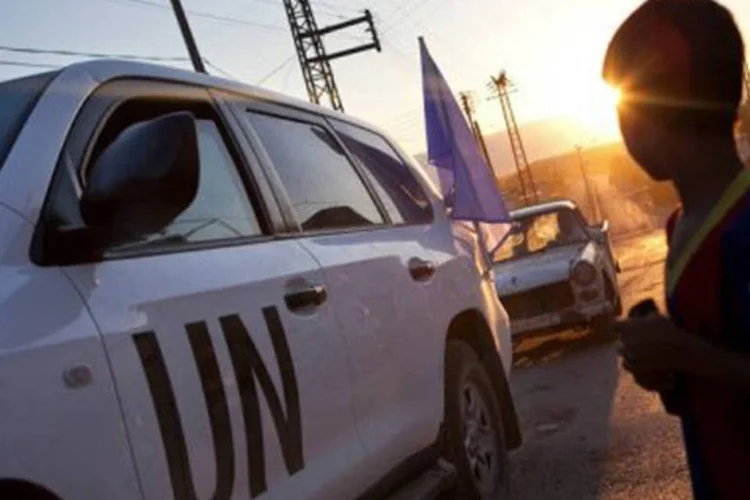 
	S&iacute;rios se re&uacute;nem em torno de ve&iacute;culos da ONU no vilarejo de Treimsa: a resolu&ccedil;&atilde;o pede &agrave; ONU que forne&ccedil;a &agrave; comiss&atilde;o &quot;recursos adicionais, sobretudo humanos&quot;
 (D. Leal Olivas/AFP)