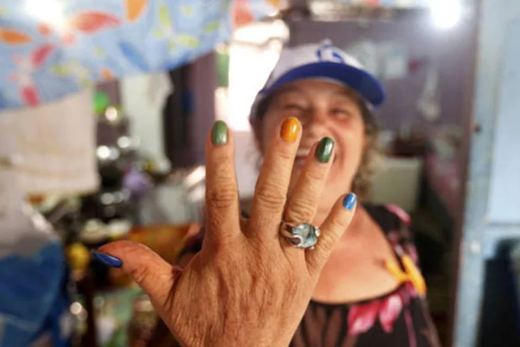 mulher exibe unhas pintadas com as cores da bandeira do Brasil (Andres Stapff / Reuters)