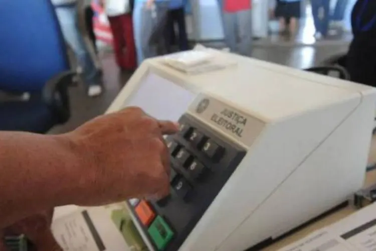 
	Pessoa utilizando uma urna eletr&ocirc;nica: foram feitos 48.735 pedidos de voto em tr&acirc;nsito para o primeiro turno e 45.075 para o segundo turno
 (Elza Fiúza/Agência Brasil)