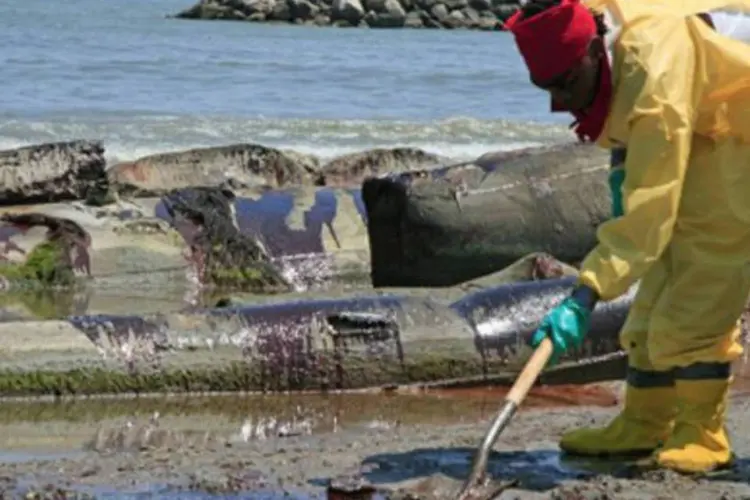 Funcionário da BP remove óleo de uma praia na Louisiana, nos EUA (.)