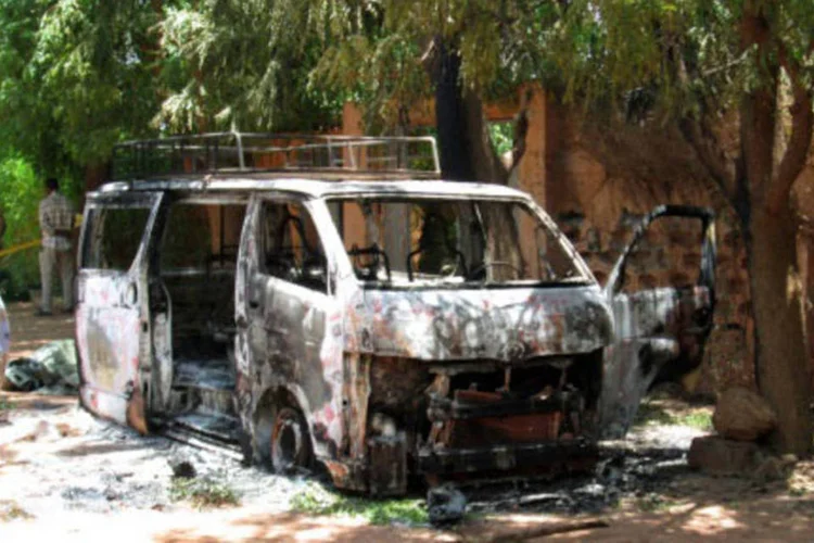 
	Ve&iacute;culo incendiado em frente ao hotel atacado: O Mali fixou o n&uacute;mero final de mortos no ataque contra o hotel em cinco agentes da miss&atilde;o da ONU, quatro soldados malineses e quatro dos terroristas agressores
 (AFP)