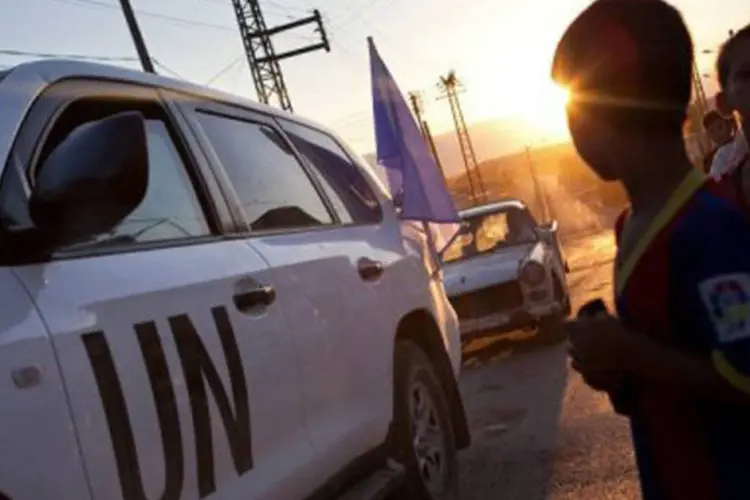 Moradores de Treimsa, na Síria, observam veículos de observadores da ONU: Rússia apoio prolongação de missão (D. Leal Olivas/AFP)