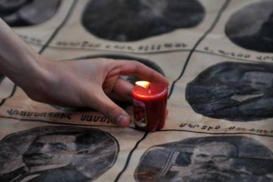 Mulher coloca vela em homenagem a intelectuais armênios que foram deportados na guerra: genocídio foi sofrido há 99 anos sob o Império Otomano (Ozan Kose/AFP)