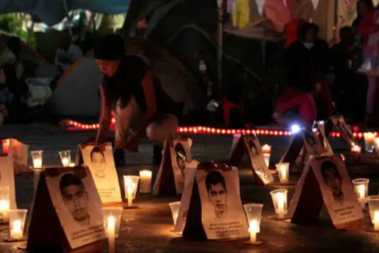 Menina acende velas durante vigília pelos 43 estudantes desaparecidos em Chilpancingo, estado de Guerrero (Pablo Spencer/AFP)