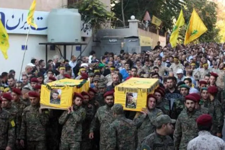 Combatentes do movimento xiita Hezbolah levam caixões de companheiros durante velório coletivo na cidade de Baalbek (AFP)