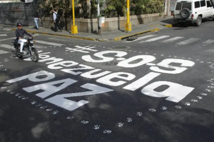 Graffiti onde se lê S.O.S Venezuela, Paz, em distrito de Caracas: no entanto, o clima de tensão se mantém (Tomas Bravo/Reuters)