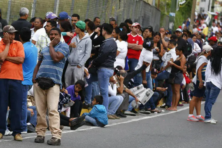 Venezuelanos fazem fila no lado de fora de um supermercado estatal em Caracas, na Venezuela, nesta sexta-feira (Jorge Silva/Reuters)