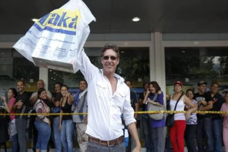 Consumidor carrega sacola do lado de fora de loja na Venezuela: o país vive uma crise econômica marcada por uma inflação que chega a 54,3% ao ano (Reuters)