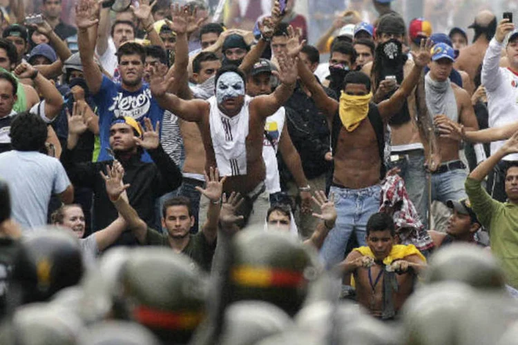 Venezuela: partidários do líder da oposição Henrique Capriles enfrentam a polícia durante manifestações pedindo a recontagem dos votos da eleição de domingo, em Caracas. (REUTERS/Christian Veron)