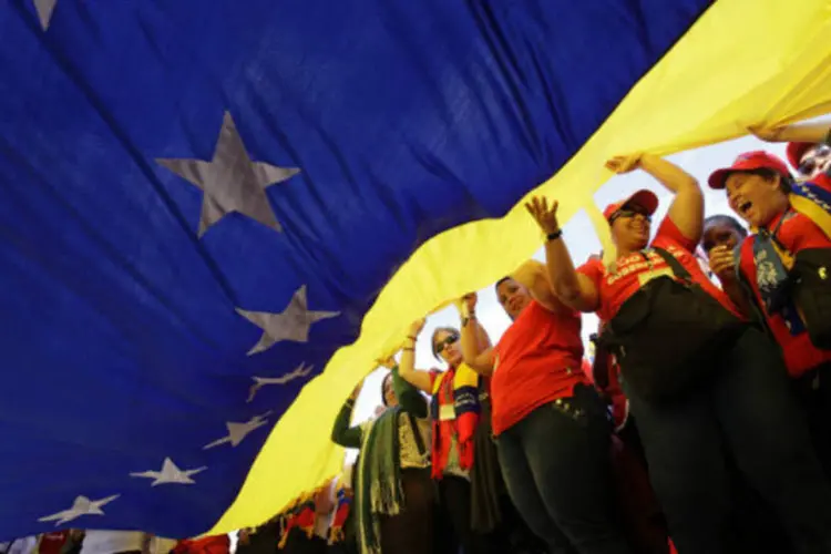 Estudantes venezuelanos agitam uma gigantesca bandeira nacional durante um encontro em demonstração de apoio ao presidente Hugo Chávez em Havana (REUTERS / Desmond Boylan)