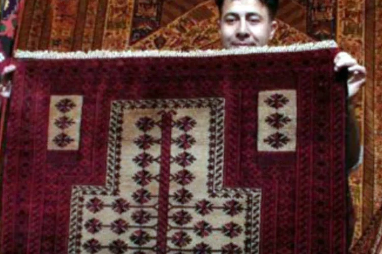 Vendedor iraniano mostra um verdadeiro tapete persa, na cidade de Isfahan (AFP)